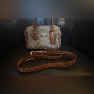 Small Coach handbag with crossbody strap.